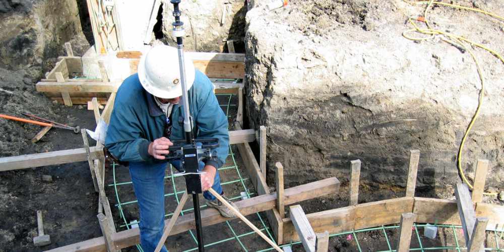 Surveyor assessing construction staking